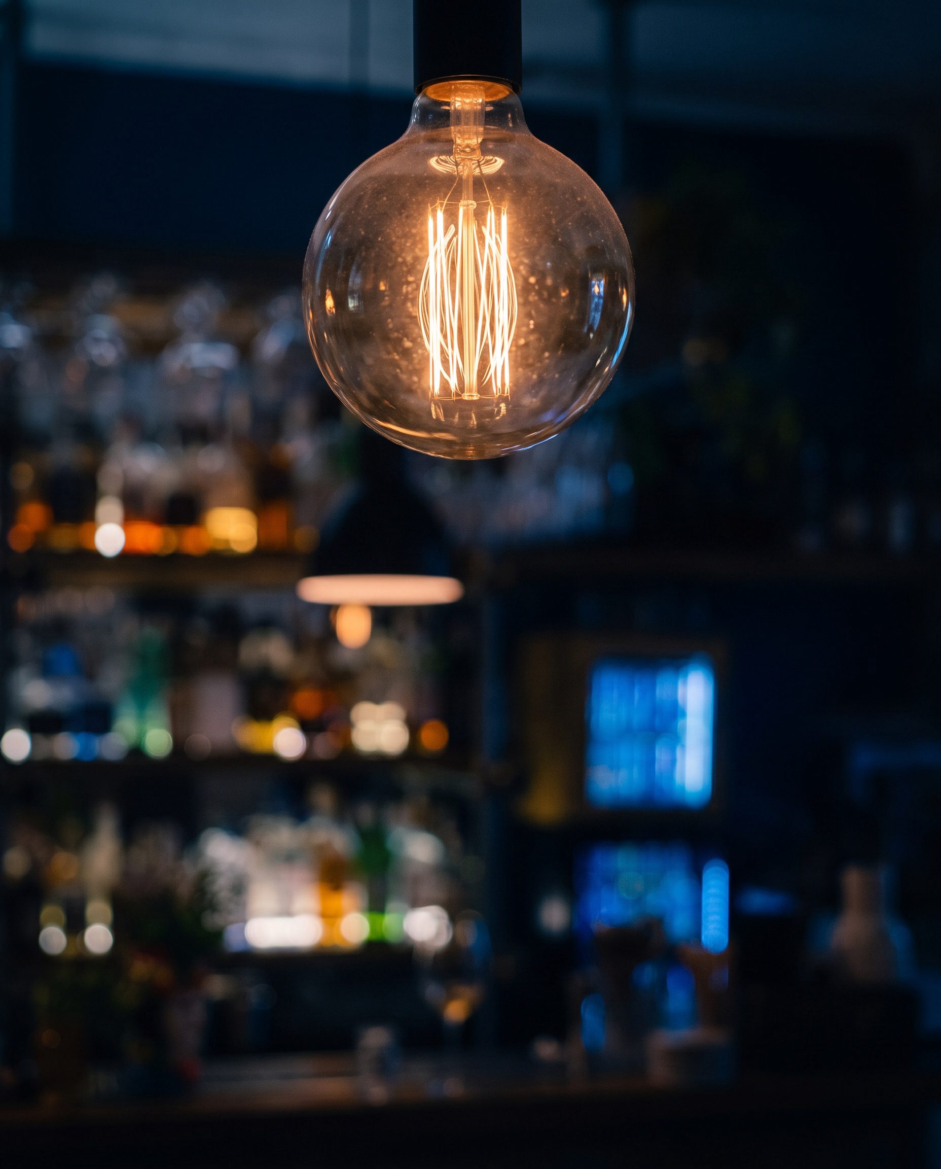 Una lampadina a filamento accesa sopra il banco di Ai Bagnoli.